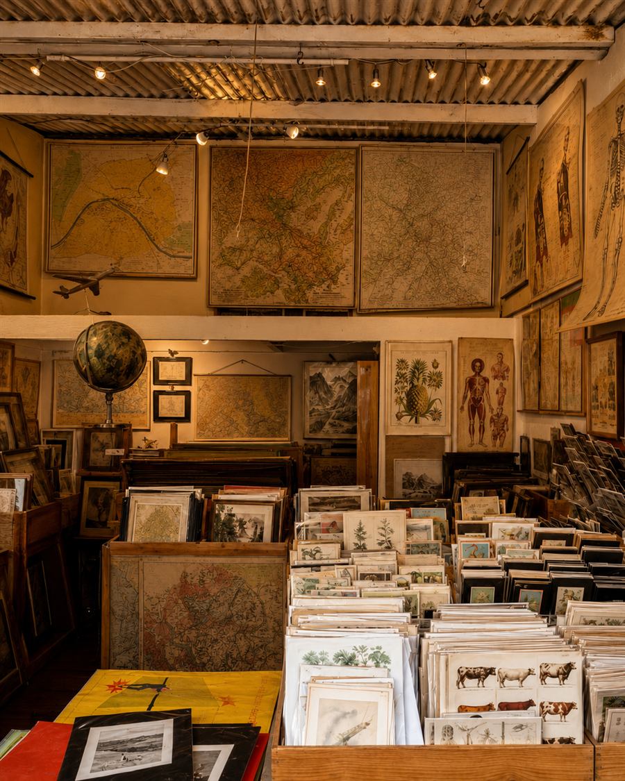 Antique maps and prints stacked at a Saint-Ouen flea market stall.